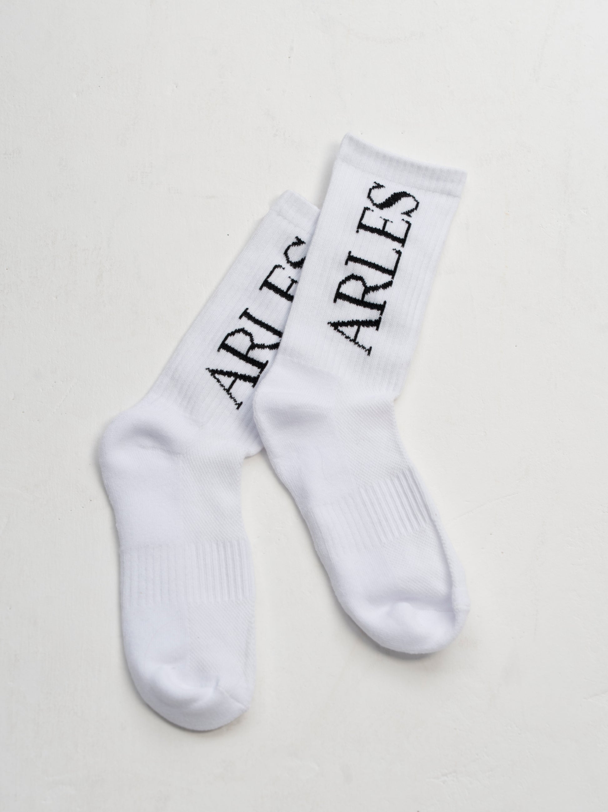 White socks with 'ARLES' text on a light gray background